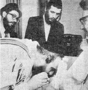 Rabbi bent over baby, sucking blood from circumcision wound